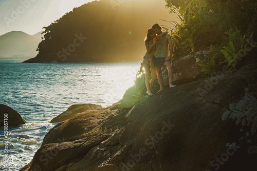 Sunny photo. Couple standing and hugging jn the sea cost cliff