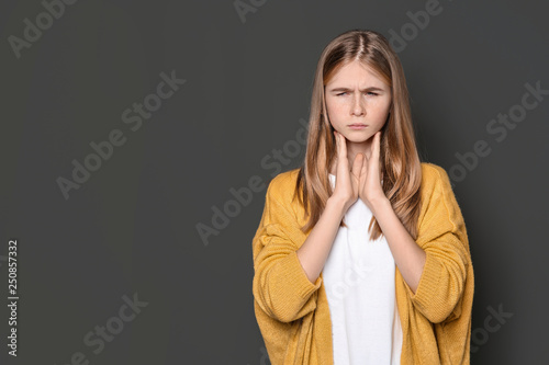 Teenage girl suffering from cough on dark background. Space for text