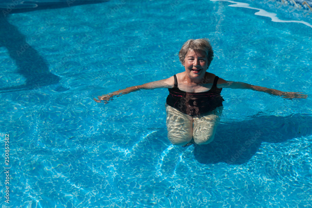 Senior woman doing exercises in a pool