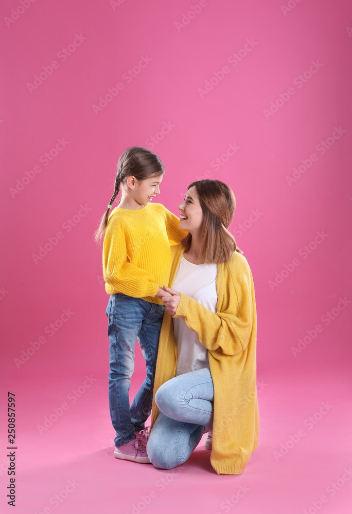 Happy woman and daughter in stylish clothes on color background Happy woman and daughter in stylish clothes on color background