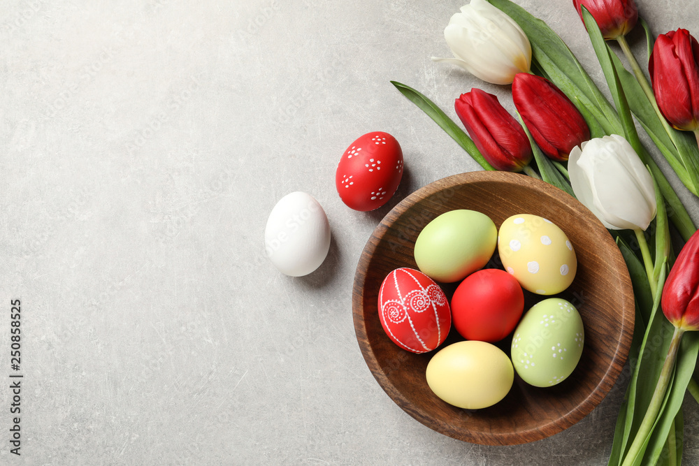 Flat lay composition of painted Easter eggs and spring flowers on light background, space for text Flat lay composition of painted Easter eggs and spring flowers on light background, space for text