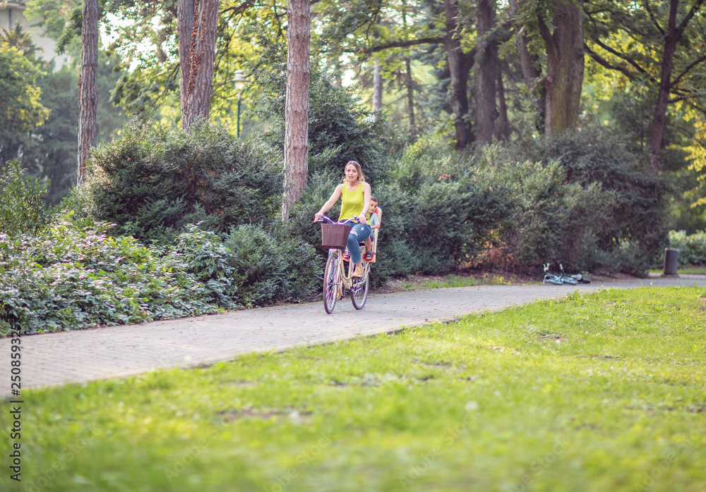 Fototapeta premium mother and son on bicycles in park.