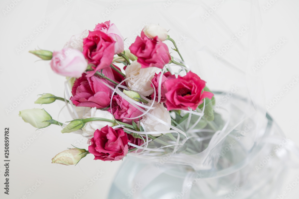 Bouquet of red Eustoma flowers in vase on white background