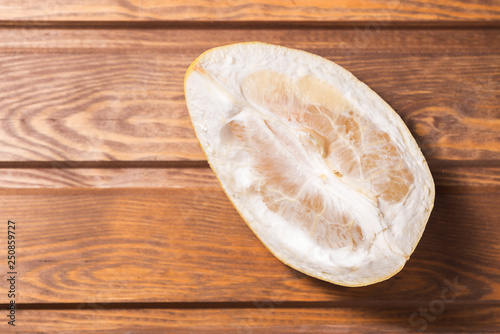peeled citrus fruit Pomelo on a wooden background photo