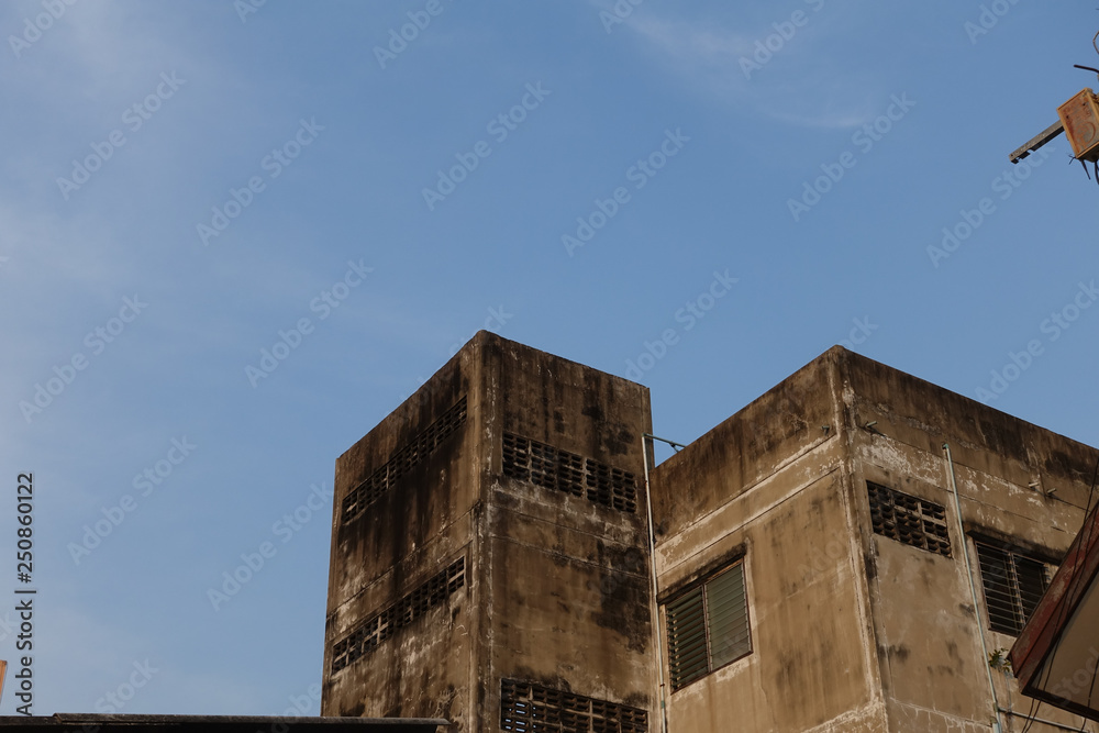 Old painted top floor of building and blue sky background Old painted top floor of building and blue sky background