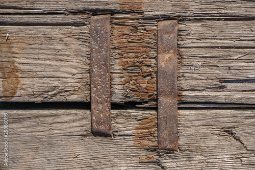 Old boards fastened with metal brackets, background and texture