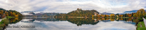 Beautiful autumn landscape around Lake Bled with St. Martin's Parish Church and ships, castle and island