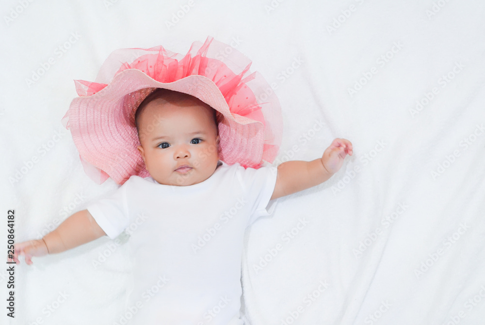Asian newborn baby girl wear pink beach hat and white dress on white background. Baby and her beach wears on white towel background. Asian newborn baby girl wear pink beach hat and white dress on white background. Baby and her beach wears on white towel background.