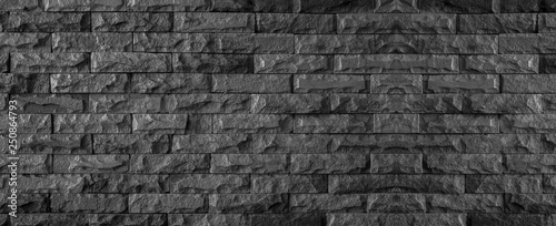 panorama of black brick wall of dark stone texture and background