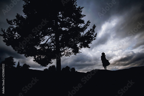 Depressed young woman sitting under the tree