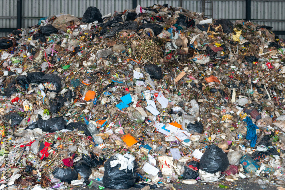 A pile of garbage in a waste storage area at a waste sorting plant