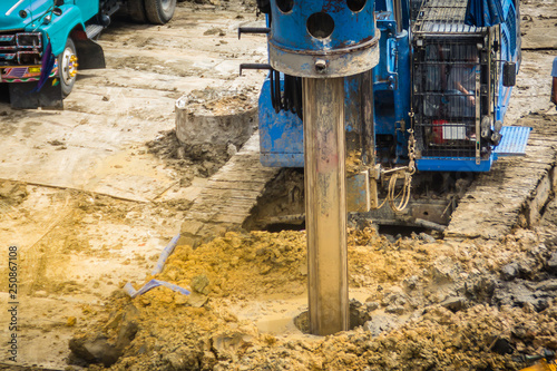 Hydraulic drilling machine is boring holes in the construction site for bored piles work. Bored piles are reinforced concrete elements cast into drilled holes, also known as replacement piles.