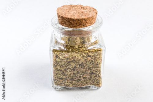 oregano herb  in a glass jar isolated on white background