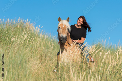 girl on horse posing in the dunes
