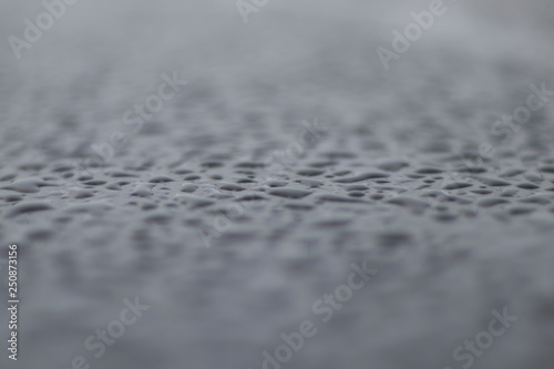 large drops on the surface of a gray car