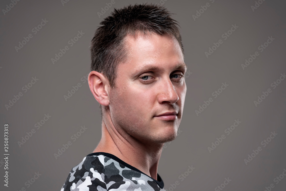 Portrait of indifferent cool young man looking at camera with skeptical expression over gray background. Portrait of indifferent cool young man looking at camera with skeptical expression over gray background.
