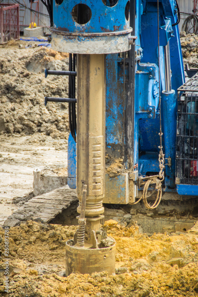 Hydraulic drilling machine is boring holes in the construction site for bored piles work. Bored piles are reinforced concrete elements cast into drilled holes, also known as replacement piles. Hydraulic drilling machine is boring holes in the construction site for bored piles work. Bored piles are reinforced concrete elements cast into drilled holes, also known as replacement piles.