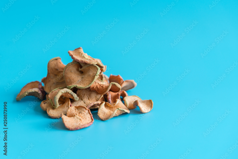 Obraz premium Dried Apples Slice In A Heap On blue Background, Ingredients For Turkish Apple Tea, Close Up. Homemade sun-dried organic apple slices
