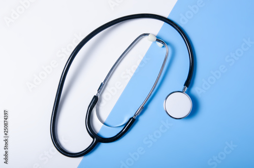 Medecine stethoscope on color white blue background, flat lay, top view