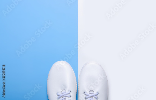 Pair of white sneakers and space for text on color background, flat lay, top view