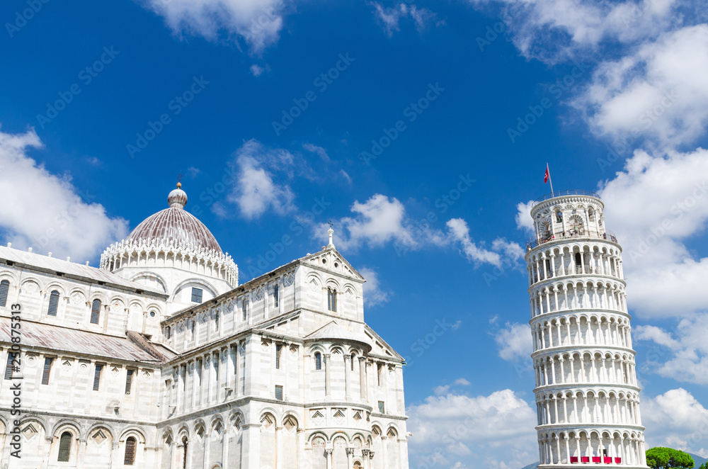 Pisa Cathedral Duomo Cattedrale and Leaning Tower Torre on Piazza del Miracoli square, blue sky with white clouds copy space background in sunny day, Tuscany, Italy