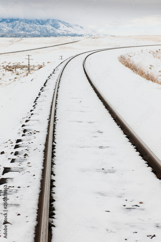 Snow-Covered Railroad Tracks in Rural Landscape Snow-Covered Railroad Tracks in Rural Landscape