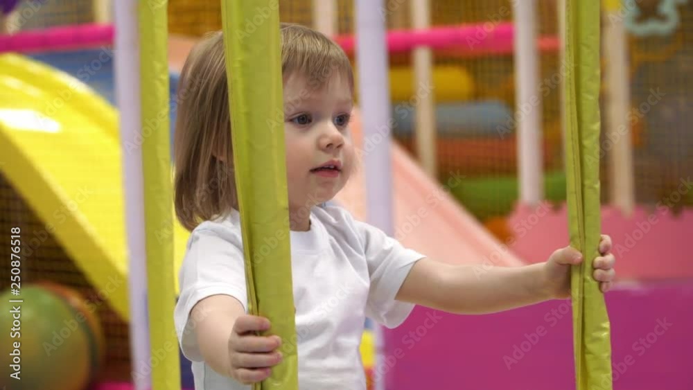 A little pretty girl is sitting on the carousel and waiting for her to go. Smiles and laughs A little pretty girl is sitting on the carousel and waiting for her to go. Smiles and laughs