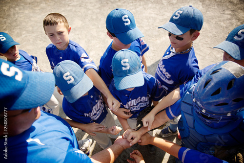 Little league players (8-9) having pep talk with coach 