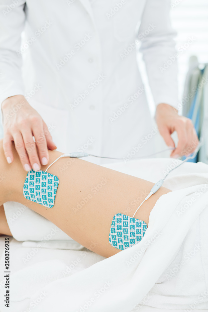 Myostimulation on the legs and hips of a slim fit woman in beauty salon. Non surgical body sculpting. anti-cellulite and body slimming therapy in cosmetological clinic, close up.