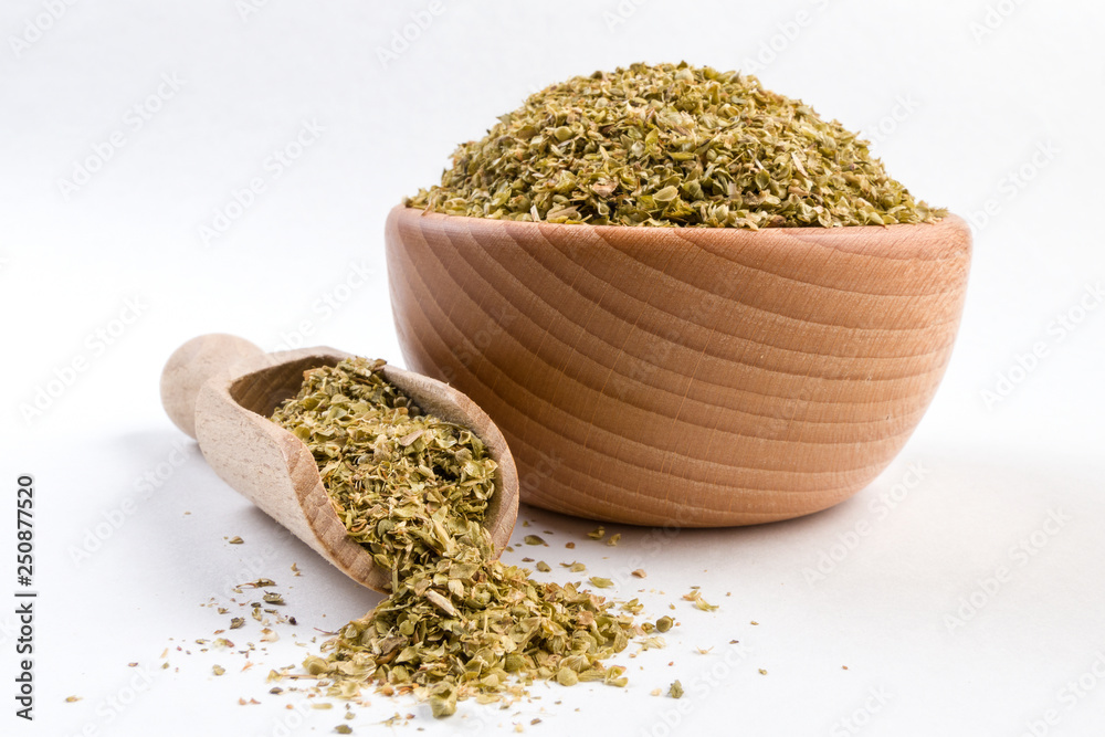 oregano herb in wooden bowl and scoop isolated on white background oregano herb in wooden bowl and scoop isolated on white background