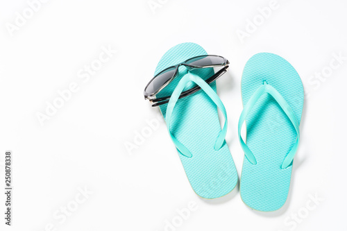 Summer travel concept. Flip flops and sunglasses on white. 