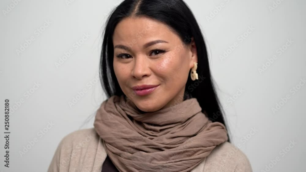 Asian Woman with a Gentle Smile on a White Background. Asian Woman with a Gentle Smile on a White Background.