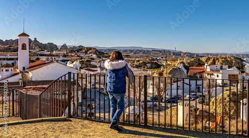 Woman tourist looks at cave homes neighborhood in Guadix, Andalusia, Spain.