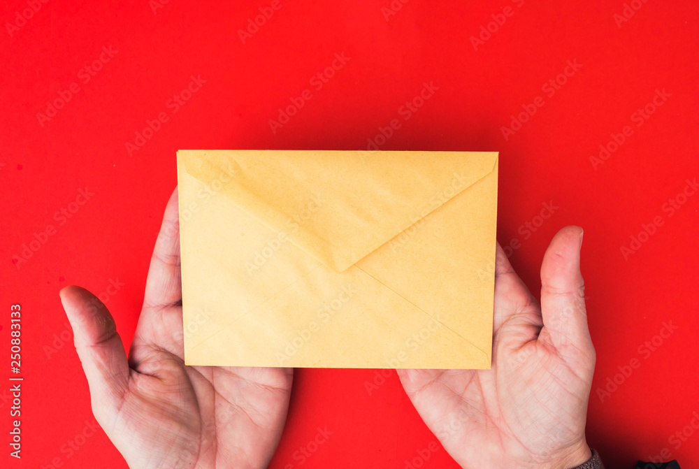 A woman hand hold a envelope and post card on isolated background A woman hand hold a envelope and post card on isolated background