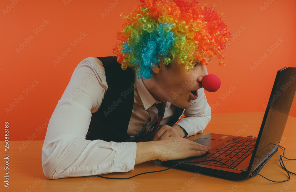 Office worker in clown wig, clown concept at work. Businessman at the  computer, work on a laptop Stock Photo | Adobe Stock