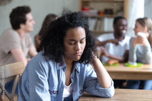 Bild auf Leinwand Upset mixed race woman offended by friends, feeling unhappy