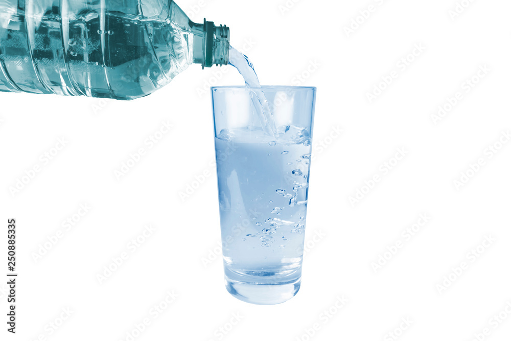 Water is poured from a plastic bottle into a glass, on a white background Water is poured from a plastic bottle into a glass, on a white background
