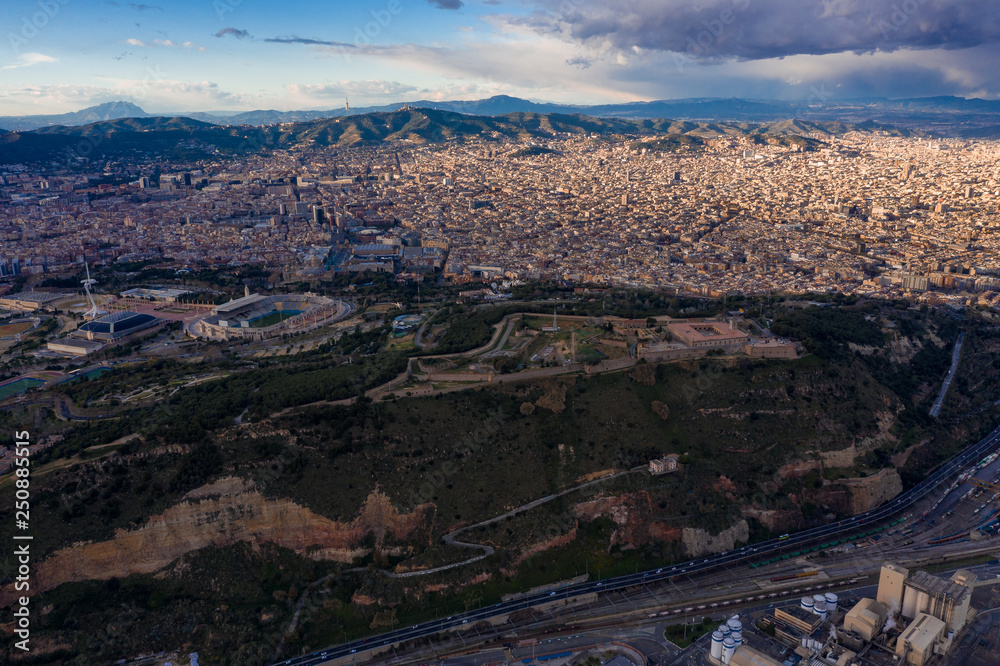 Aerial photo of Barcelona panorama before storm. City with shadows from clouds. Moody weather. Montjuic Castle on the foreground