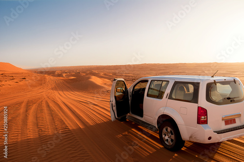 Off-road vehicle in the wahiba sands desert dunes at sunset (Oman) photo