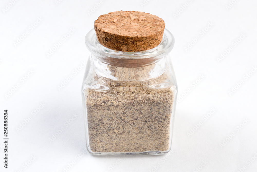 ground white pepper in a glass jar isolated on white background ground white pepper in a glass jar isolated on white background