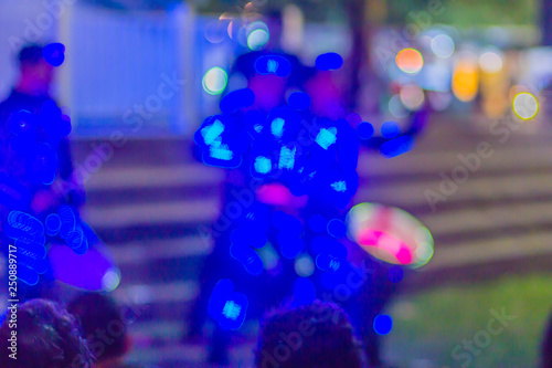 Dancers with light glowing costume dancing parade at night during new year festival. Dancers are dancing on stage in robotic costume with led lights illumination. Blurred focus with bokeh background.