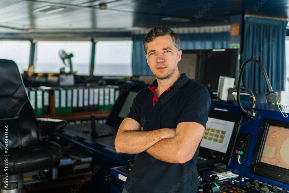 Marine navigational officer during navigational watch on Bridge . Work at sea Marine navigational officer during navigational watch on Bridge . Work at sea