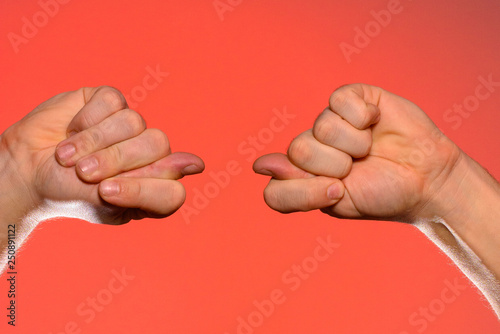 Man's hand with a fig's sign close-up is isolated on a red background photo