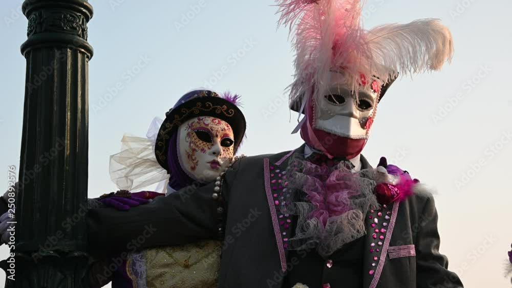 Venice - carnival masks are photographed with tourists in Piazza San Marco