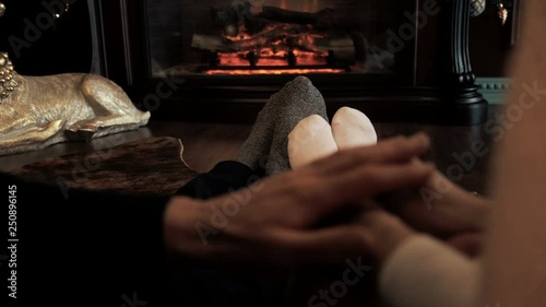 Young couple near the fireplace at home winter legs close-up