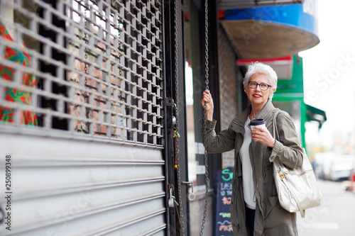 Portrait of senior woman opening her store 