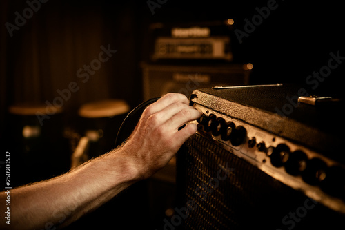 Hand turning dials on guitar amplifier 
