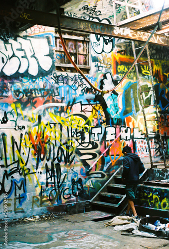 Lonely street boy wandering through abandoned Graffiti House