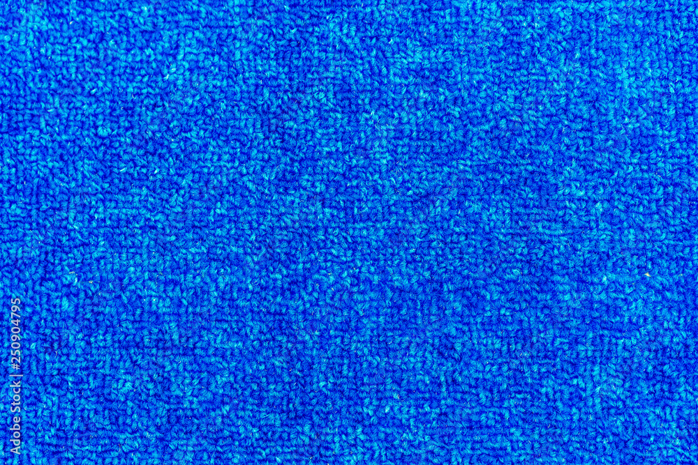 Texture of a blue carpet with dense weaving.