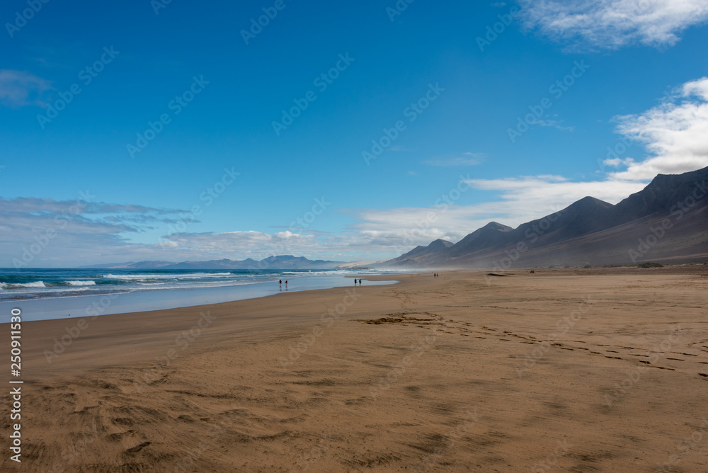 Cofete beach, Jandia peninsula, Fuerteventura, Canary Islands. Footprints on the sand and high mountains on the shore. 